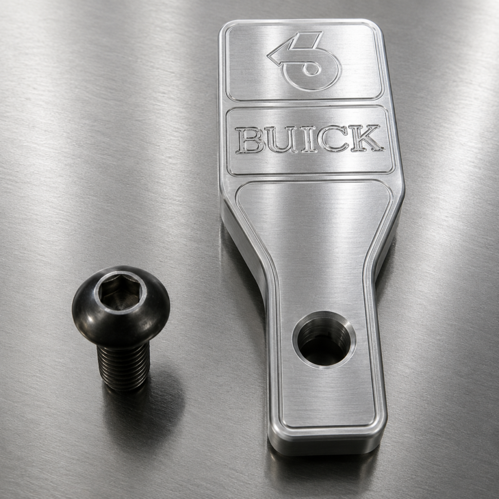 Buick metal part with screw on table.