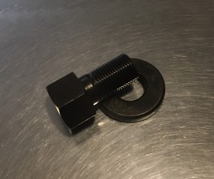 Black threaded bolt and washer on metal