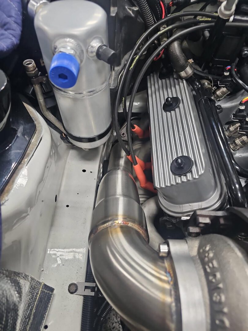 Car engine bay with custom exhaust